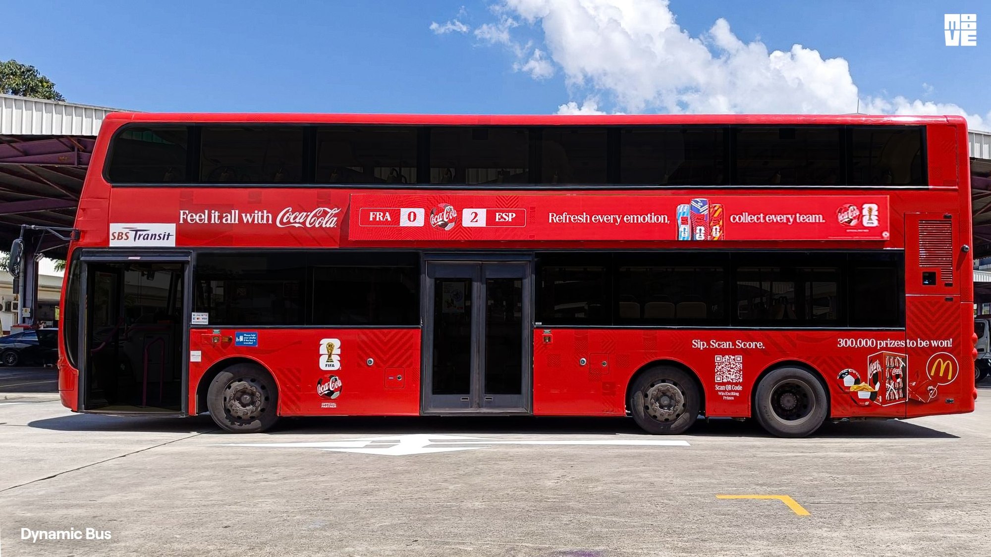 SBS Transit double-decker bus in Singapore with the Coca-Cola FIFA World Cup 26 strip screen running along its side, showing a live match score and the Refresh every emotion, collect every team line