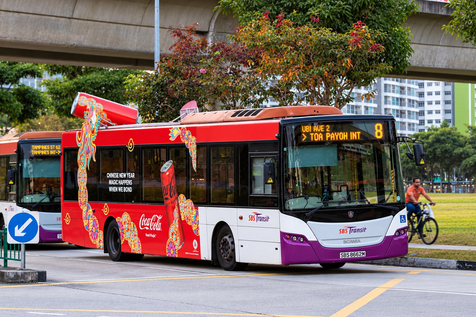 Coca-Cola Chinese New Year bus transit wrap on a moving SBS Transit bus, side view with the dragon running the length of the bus