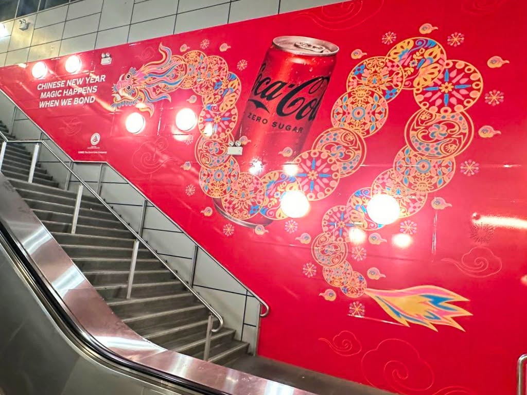 Coca-Cola Chinese New Year escalator and stairwell decal, a dragon made of gold Chinese pattern medallions wrapping down the stairwell alongside a large Coca-Cola Zero Sugar can